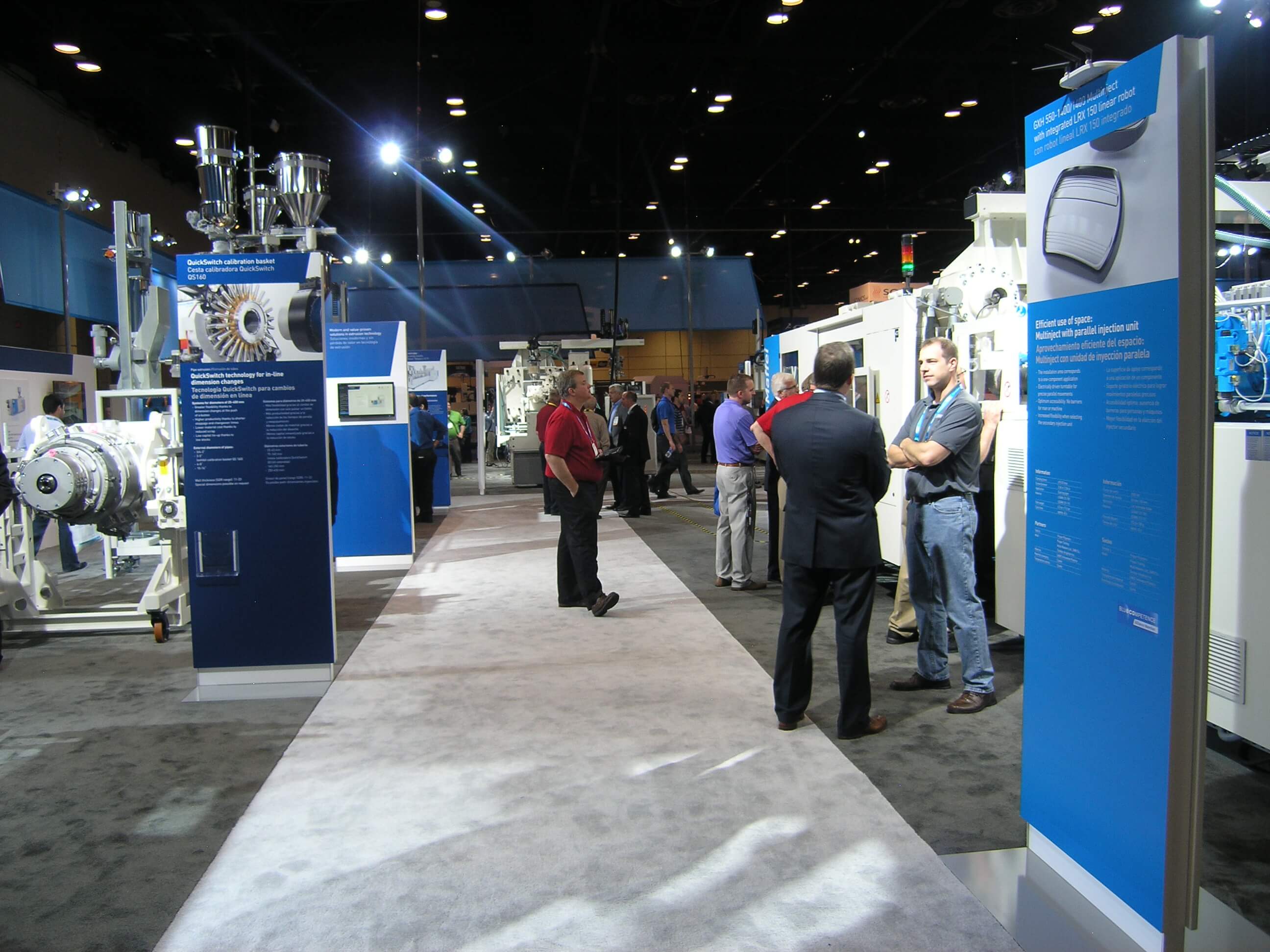 Large products displayed in trade show exhibit with graphic kiosks