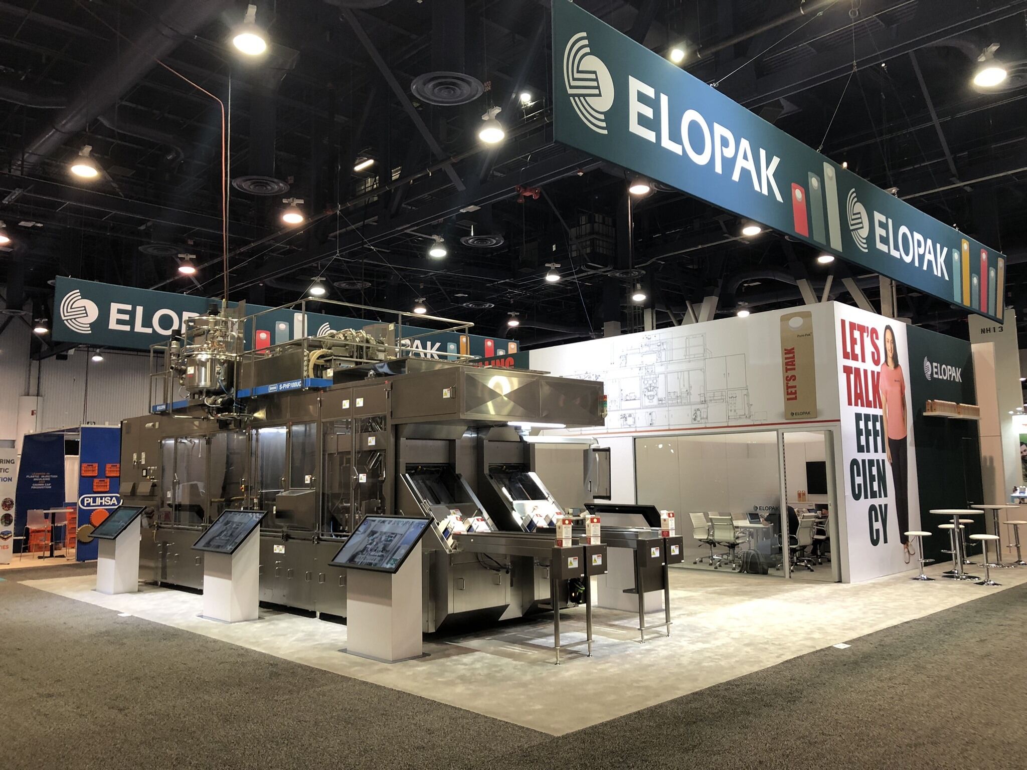 Elopak island trade show exhibit with large machinery product